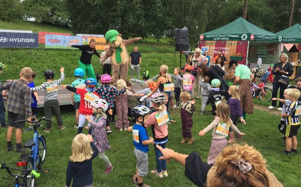 Børn danser sammen med maskotten fra Kids Tour på Kalvøen i august 2023. Foto: Frederikssund Kommune.