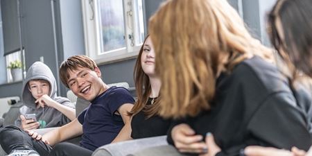 Unge sidder i en sofa og snakker og griner. Foto: Kenneth Jensen, Frederikssund Kommune.
